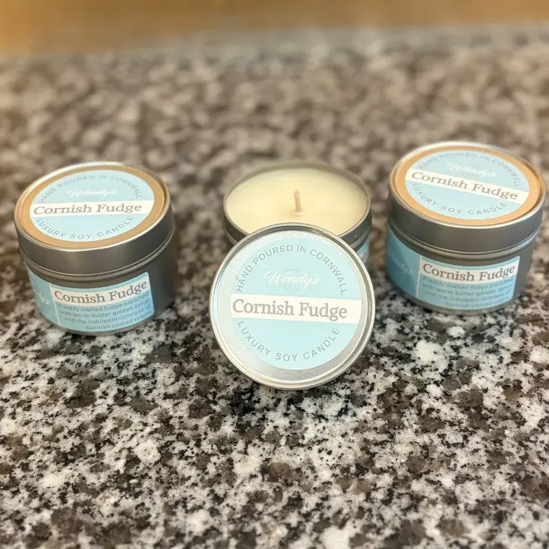 Three Nanny Wendy's Cornish Fudge luxury soy candles in silver tins, one open showing the wax and wick